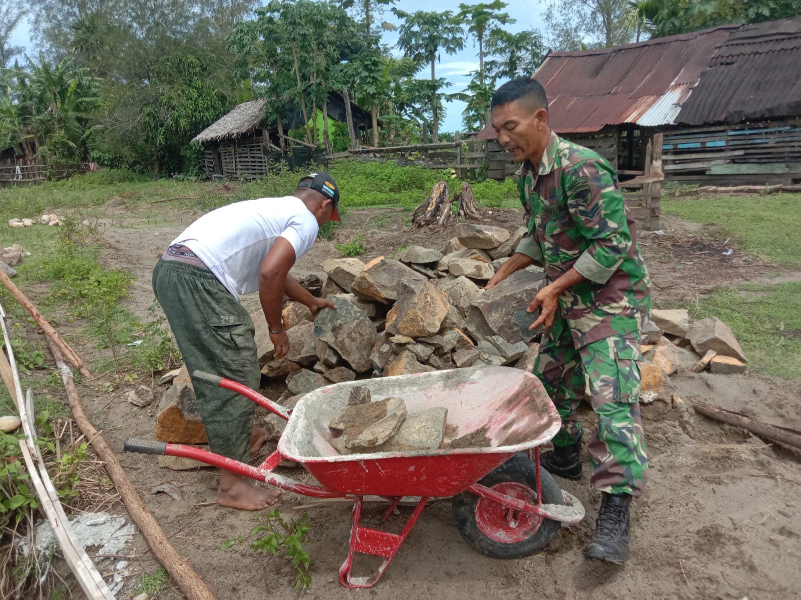 Meringankan Beban Warga, Babinsa Koramil 09/Samatiga Sertu Buchari Muslim Bantu Angkat Batu Pondasi Rumah di Desa Suak Seumaseuh