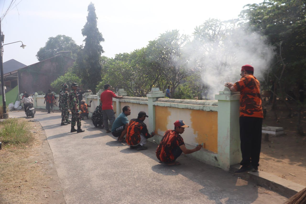 BATALYON INFANTERI 407/PK BERSAMA PEMUDA PANCASILA DAN MASYARAKAT LAKSANAKAN KARYA BAKTI PEMBERSIHAN DAN PENGECATAN PAGAR MAKAM DI DESA TEMBOK KIDUL